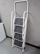 A folding four tread stepladder with hand rails