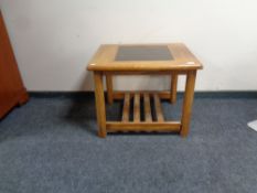 A teak coffee table with glass inset panel