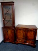 A mahogany glazed door corner cabinet with cupboard beneath,