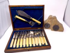 A silver plated canteen of fish cutlery together with a pair of bookends made with stone from the