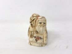 A Japanese carved bone netsuke - Village elder carrying a sack on his shoulder.