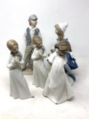 A Nao figure of a seated girl with puppy together with four others