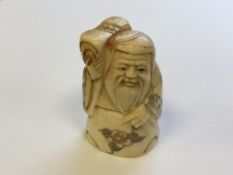 A Japanese carved bone netsuke - village elder carrying wares on his shoulder