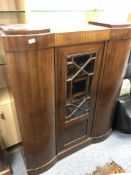 A continental triple door cabinet with glazed central panel door,