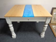 A contemporary oak topped dining table with a resin inset panel on a painted base
