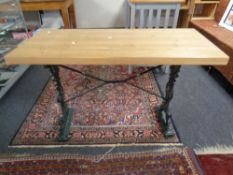 A pine topped table on a cast iron twin pedestal base