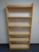 A set of pine open bookshelves together with a pine cube storage unit and a further contemporary