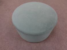 A 20th century circular footstool upholstered in a turquoise fabric