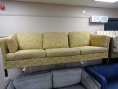 A 20th century Danish three seater settee upholstered in a floral fabric