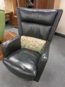 A 20th century black leather wingback armchair on metal base