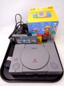 A Sony Play Station console with leads and controllers, a Colin Mcrae game,