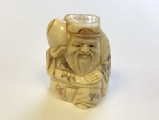 A Japanese carved bone netsuke - village elder carrying fruit on his shoulder