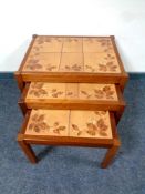 A nest of three twentieth century teak tiled tables