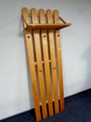 A pine wall mounted coat rack with shelf