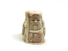 A Japanese carved bone netsuke - Village elder holding a scroll.