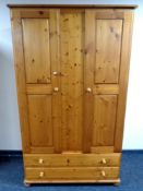 A pine double door wardrobe fitted two drawers beneath,