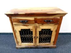 A mango wood double door cabinet fitted two drawers above,