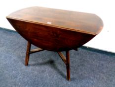 An Ercol solid elm and beech drop leaf table and four Ercol rail back dining chairs