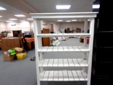 A painted white wooden four tier open shelf, width 131 cm,