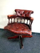 A buttoned burgundy leather swivel desk chair CONDITION REPORT: Currently unstable