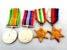 Four World War II medals on ribbons to include The War Medal, The Defence Medal,
