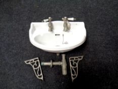 A ceramic sink with taps including wall bracket