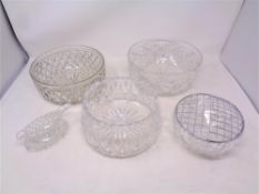 Four cut crystal bowls together with a glass sauce boat