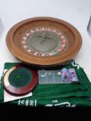 A roulette wheel on stand together with cloth pocket change dish and chips