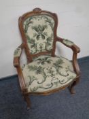 A carved beech French salon armchair upholstered in a tapestry fabric