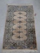 An Afghan rug on cream ground,