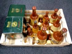 A crate containing a quantity of Bells Scotch Whisky decanters (empty,