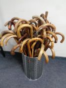 A metal bin containing over 50 vintage walking sticks and parasols