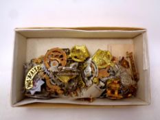 A box containing a large quantity of military and regimental cap badges