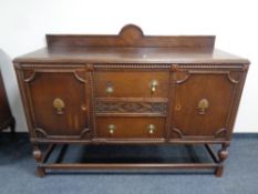 An early twentieth century oak shaped fronted sideboard