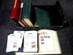 A crate containing seven folders and books containing world stamps,