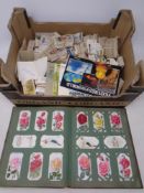 A box containing an album and a large quantity of assorted cigarette and tea cards to include Wills,