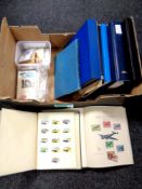 A box containing eight folders and books containing world stamps,