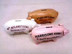 Three cast iron pig money boxes bearing advertisement