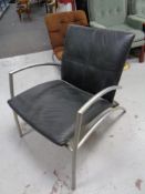 A Scandinavian tubular metal armchair upholstered in black leather