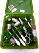 A green velvet cased sewing kit together with assorted silver and silver plated thimbles