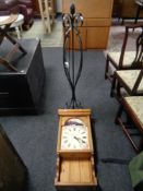 A wrought iron standard lamp together with a pine battery operated wall clock