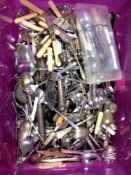 A plastic storage box containing a large quantity of silver plated and stainless steel flatware