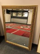 A large gilt framed bevelled overmantel mirror