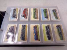 An album containing Wills, Gallagher and Players cigarette cards, medals, flowers,