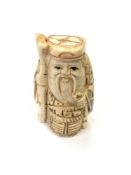 A Japanese carved bone netsuke - Village elder with a basket at his feet.