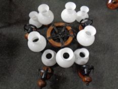 A contemporary iron and wood five way chandelier with opaque glass shades together with a set of