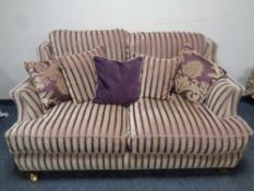 A Victorian style two seater settee upholstered in a gold and maroon striped fabric
