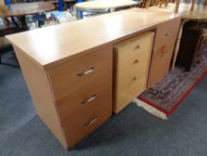 A twin pedestal writing desk in a teak finish,