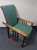 An oak armchair with adjustable back rest in studded floral upholstery