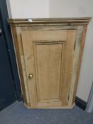 An antique pine hanging corner cabinet